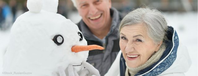 älteres paar mit Schneemann lacht
