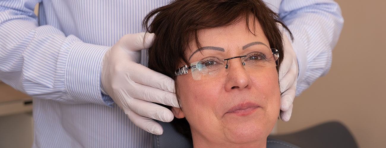 Zahnarzt Jürgen Hellmer untersucht eine CMD-Patientin: Die Funktionsdiagnostik im Bereich des Kiefergelenks ist ein wichtiger Behandlungsschwerpunkt bei den Zahnärzten im Schloss Berlin Steglitz.